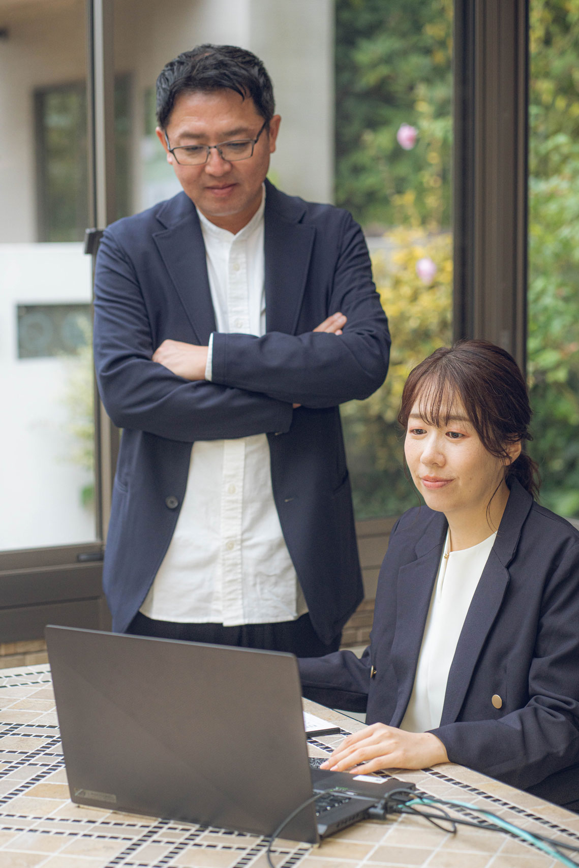 屋外でPCを見る女性と男性