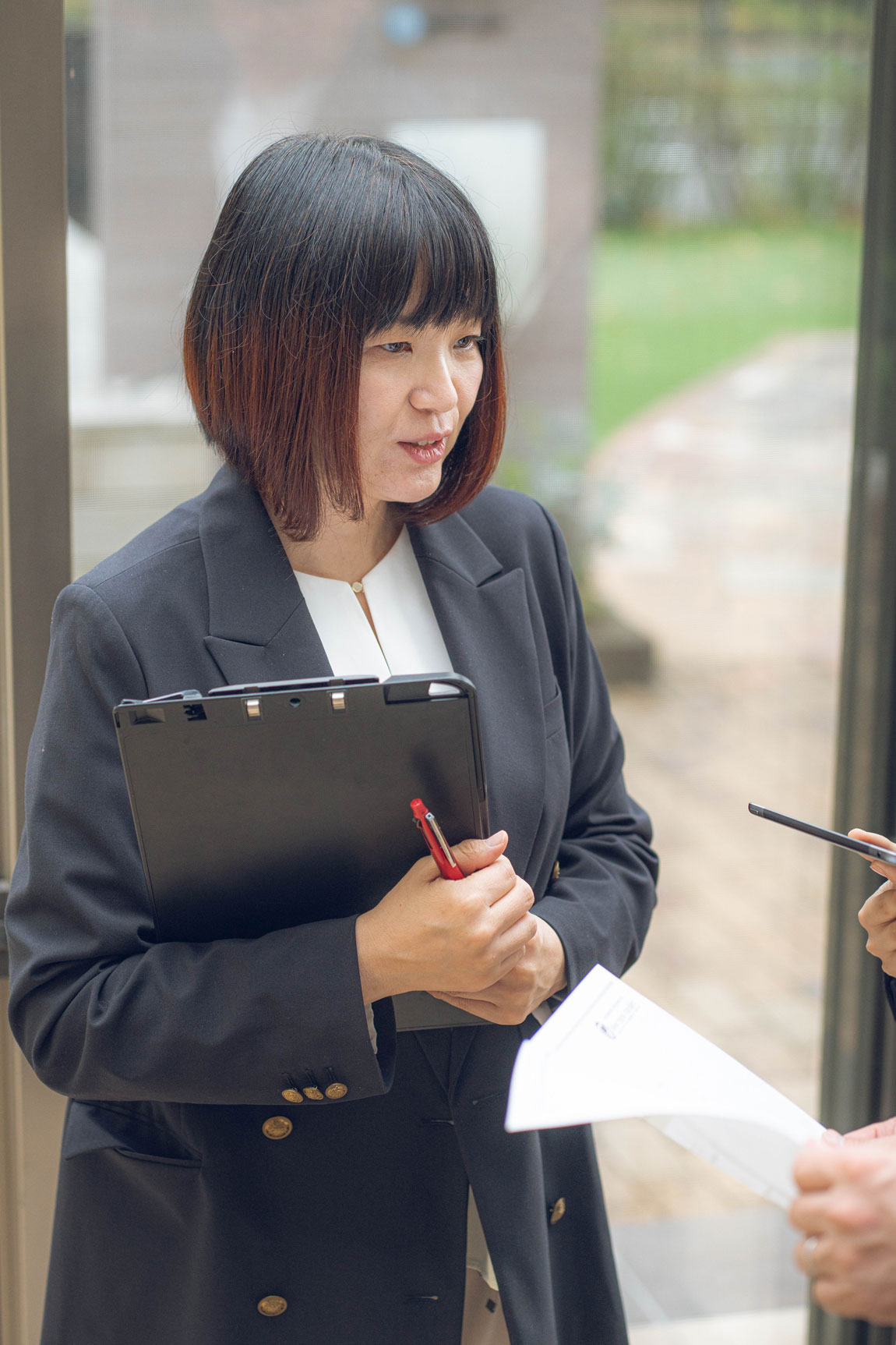 スーツを着てバインダーを持った女性